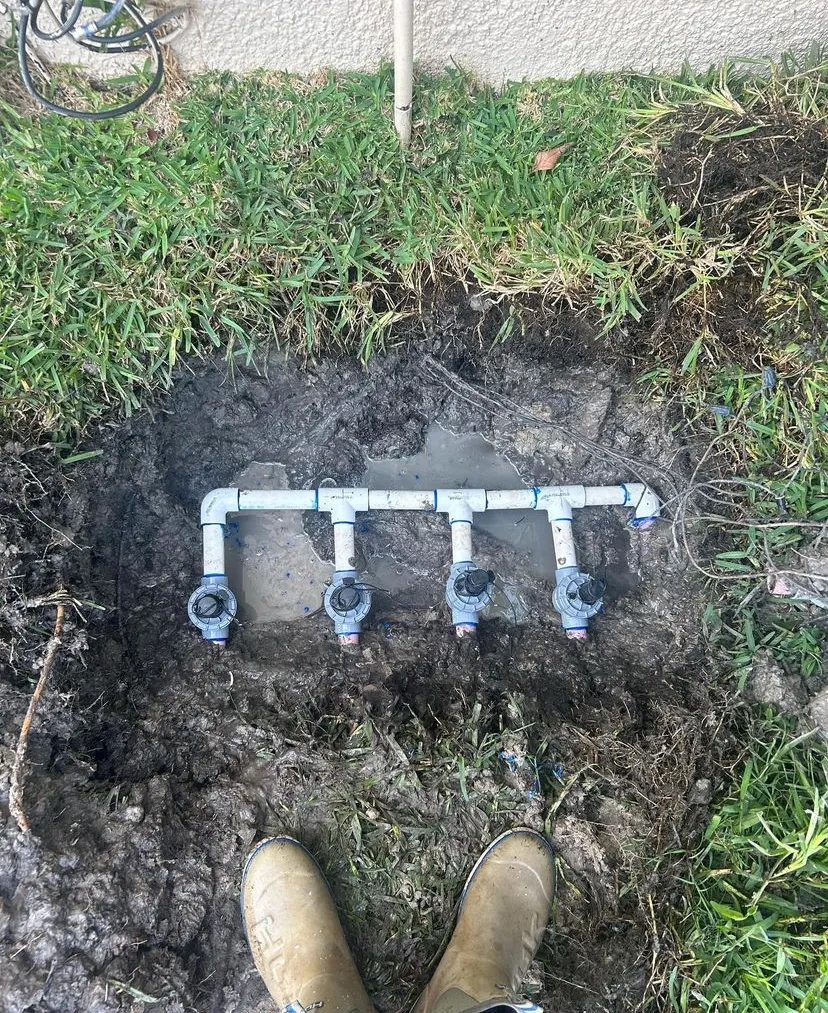 A photo of an in-ground sprinkler system with the cover removed.