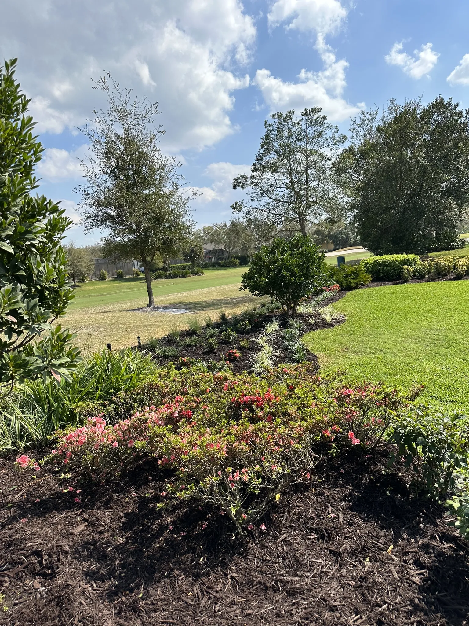 Sprinkler System A sprinkler system waters a lush green lawn and colorful flower beds on a sunny day.